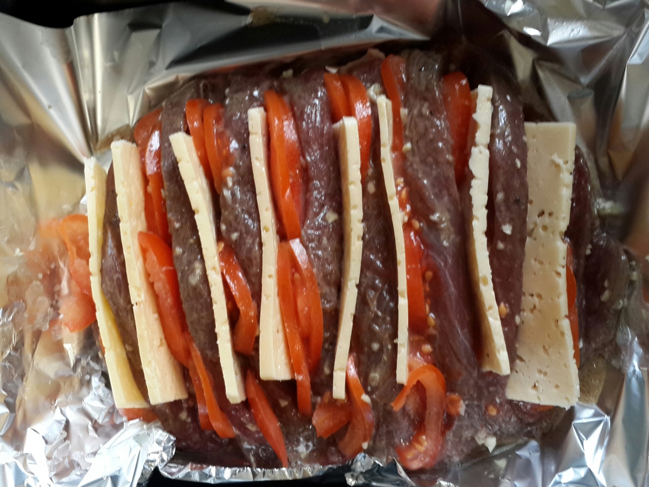 Meat Baked in a Accordion Style with Cheese and Tomatoes