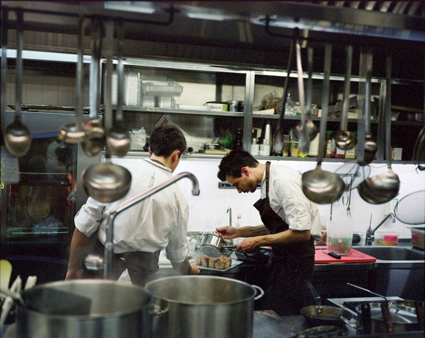 Итальянский шеф Лоренцо Кого с помощником поливают соусом брикеты из разных частей поросенка, доведенные до совершенной нежности многочасовым томлением