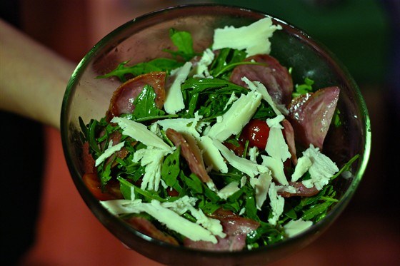 Теплый салат с руколой, помидорами черри, жареными колбасками сальчичон и пармезаном