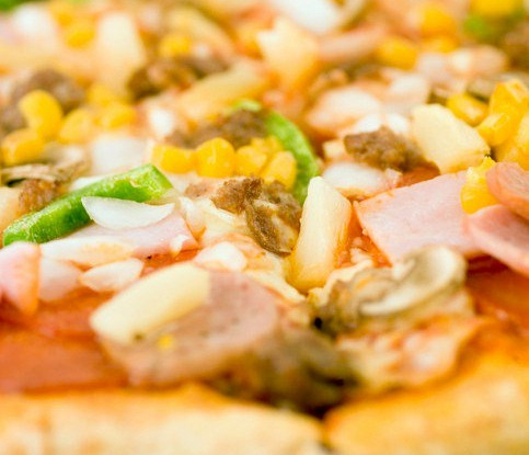 Пицца с ананасами, колбасой, сладкой кукурузой и томатами